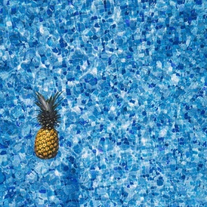 A pineapple floating on a pool.
