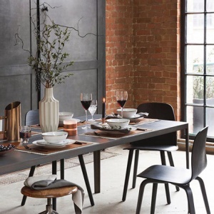 An industrial dining setting with a brick accent wall in the background. Image by Amara.