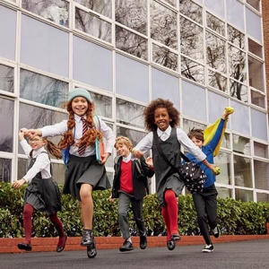 School children running outside a school building. Image by Marks & Spencer.