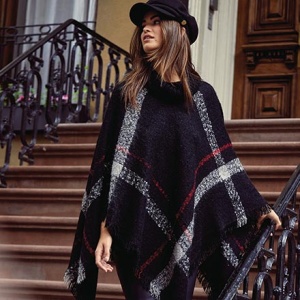 What a lovely poncho coat with a blue tartan print that looks so stylish on this woman who paired it with a black hat. Image by Lipsy.