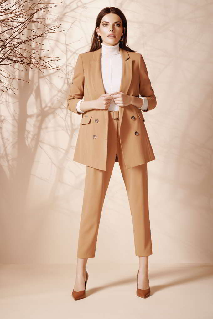 A camel pant suit paired with a white turtleneck and camel pumps always looks so chic. Image by Wallis.