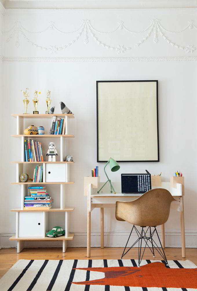 A contemporary stylish desk and chair next to a shelving unit. Love the green desk lamp that adds an element of fun. Image by Cuckooland.