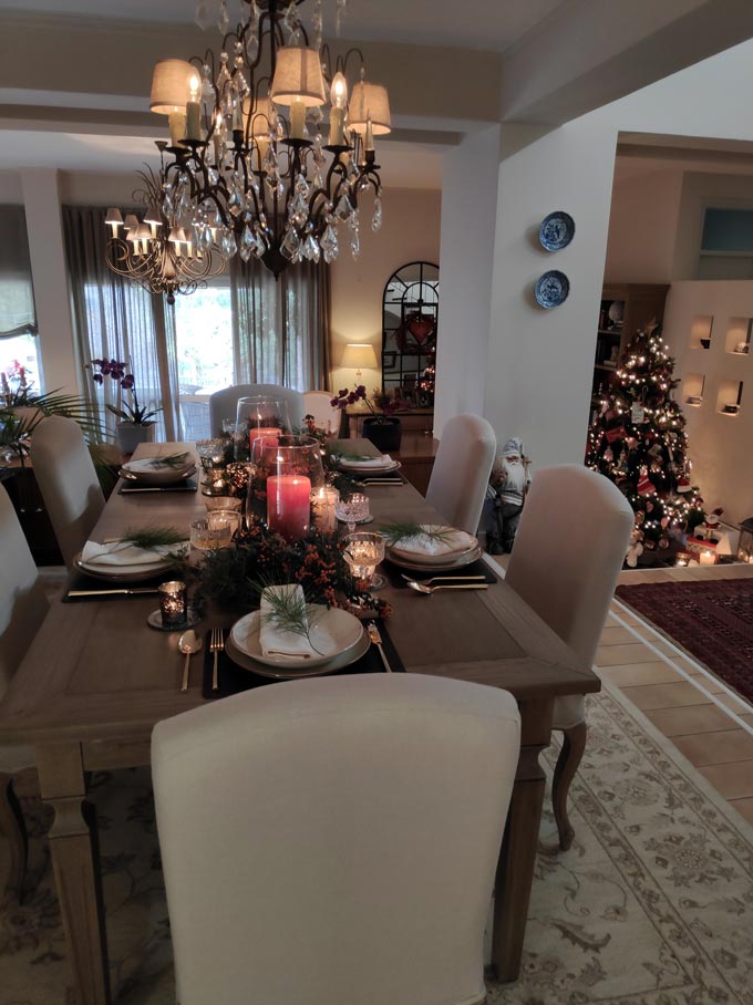 View of Elisabeth's dining table with the Christmas tabletop and partial view of her living room and Christmas tree in the background.