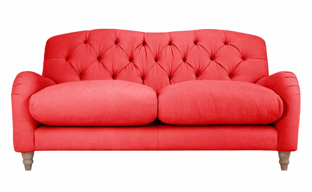 A sofa in a coral color. Image by John Lewis.