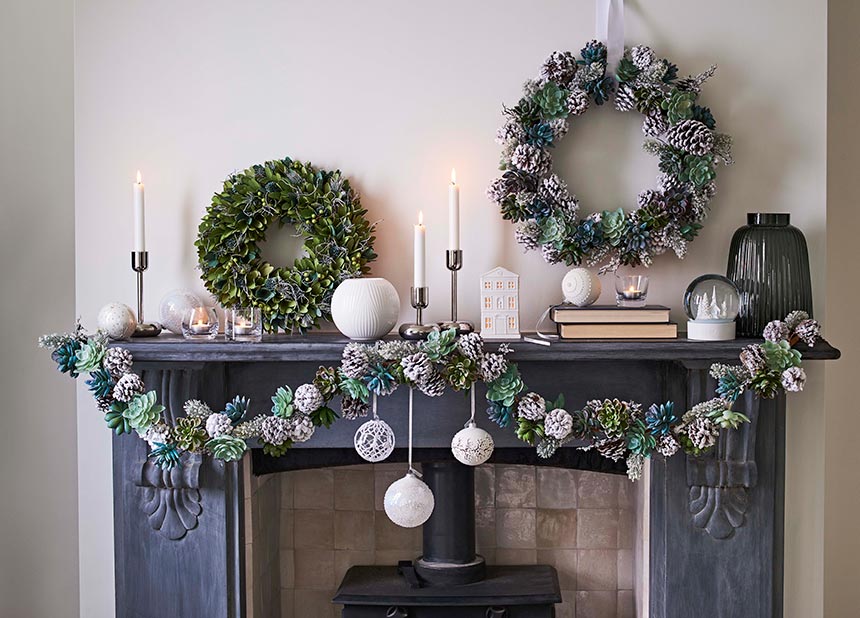 Another fireplace mantel with Christmas decorations that include candlesticks and two beautiful wreaths. Image by John Lewis.