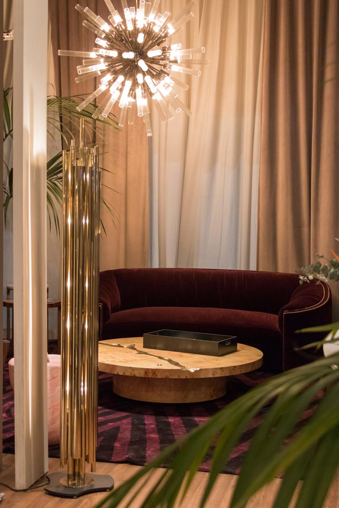 A gorgeous deep burgundy velvet curved sofa with a round coffee table at the Covet House stand at Maison et Objet Paris. Image by Covet House.