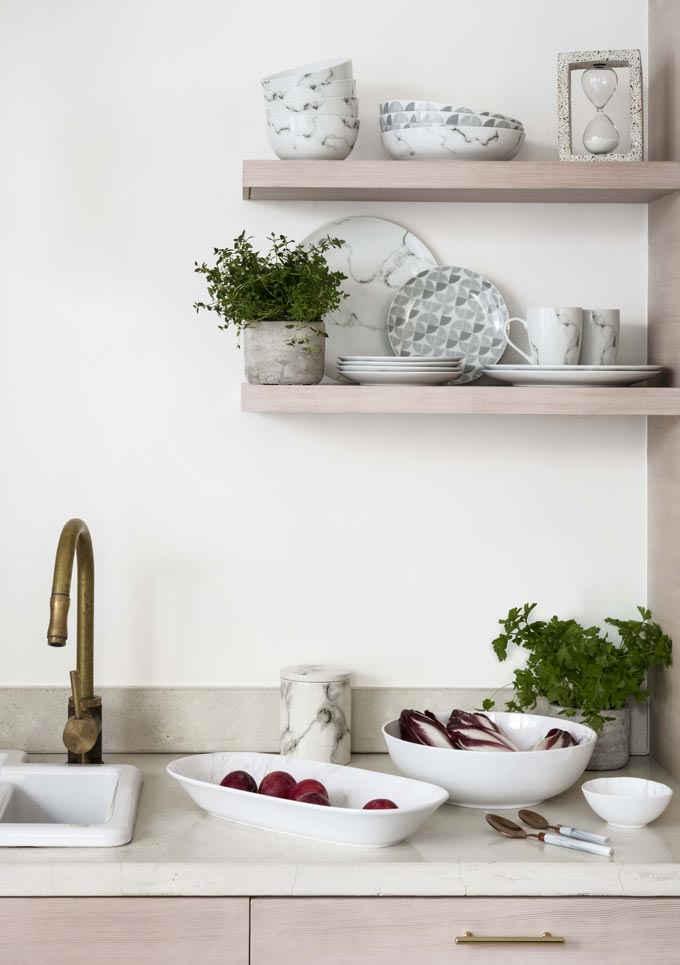 Partial view of a kitchen sink with two small open shelves on the right. Image by George Home.