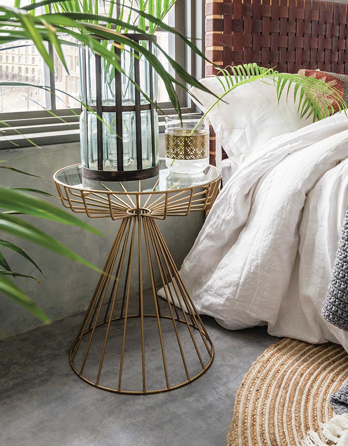 Love this the Gatsby birdcage side table used as a nightstand besides a bed with a weaved leather headboard. Image by Cuckooland.