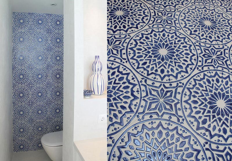 A white bathroom with an accent wall of blue and white decorative tiles. Image by G. Vega.