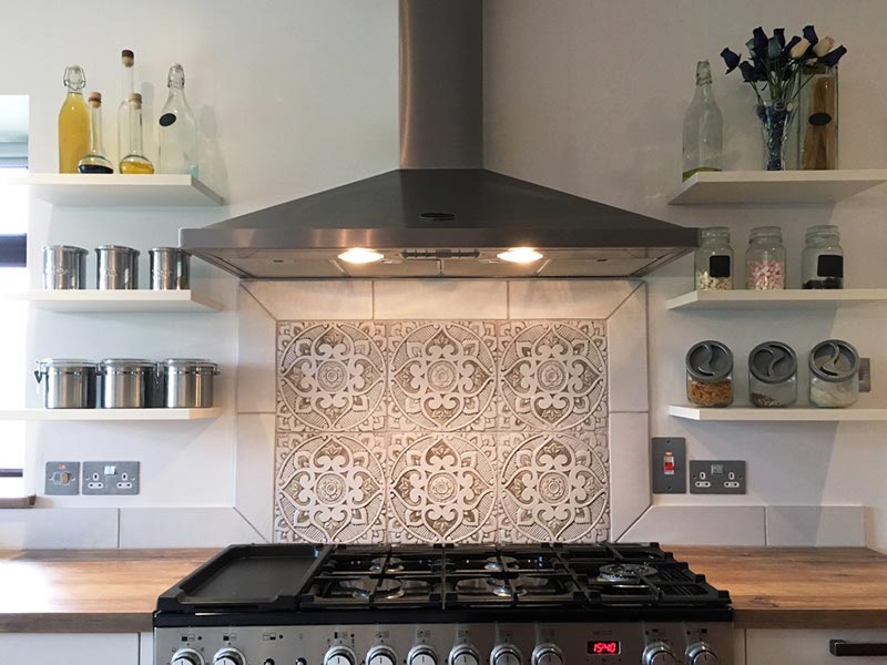 Detail of a kitchen backsplash with decorative tiles behind the cooker. Image by G. Vega.