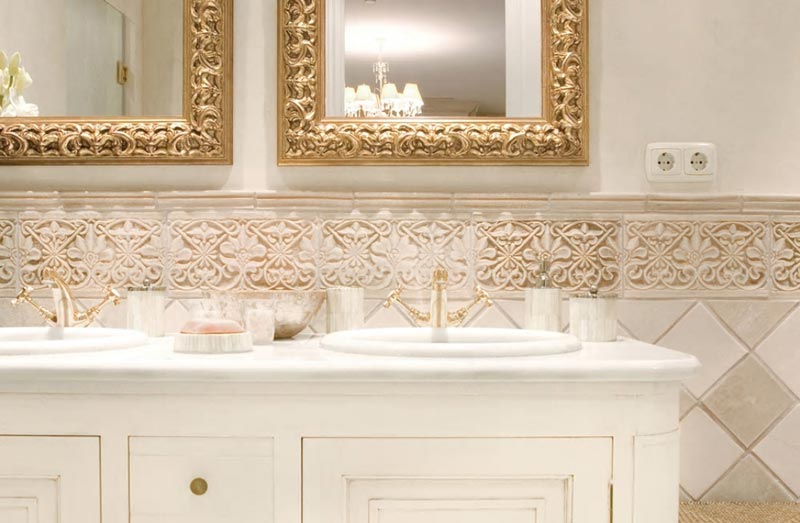 A beautiful detail of a bathroom with a double basin, double gold frame mirrors and a beautiful decorative tile backsplash. Image by G. Vega.