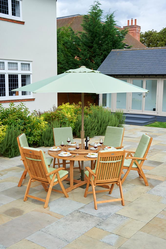 I love this minty outdoor furniture set with a teak round table, sun umbrella, and lazy Susan chairs. Image by This gorgeous set is contemporary with a traditional feel Bridgman Garden.
