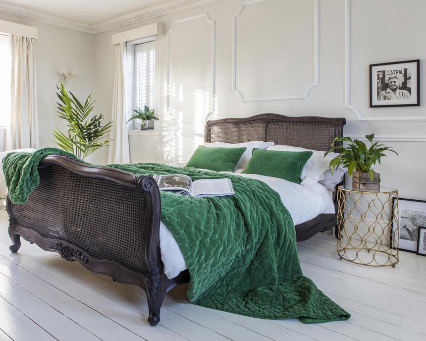 Striking elegance! A beautiful bedroom with a vintage looking bed with cane inserts at the headboard and footboard. Image by The French Bedroom Co.