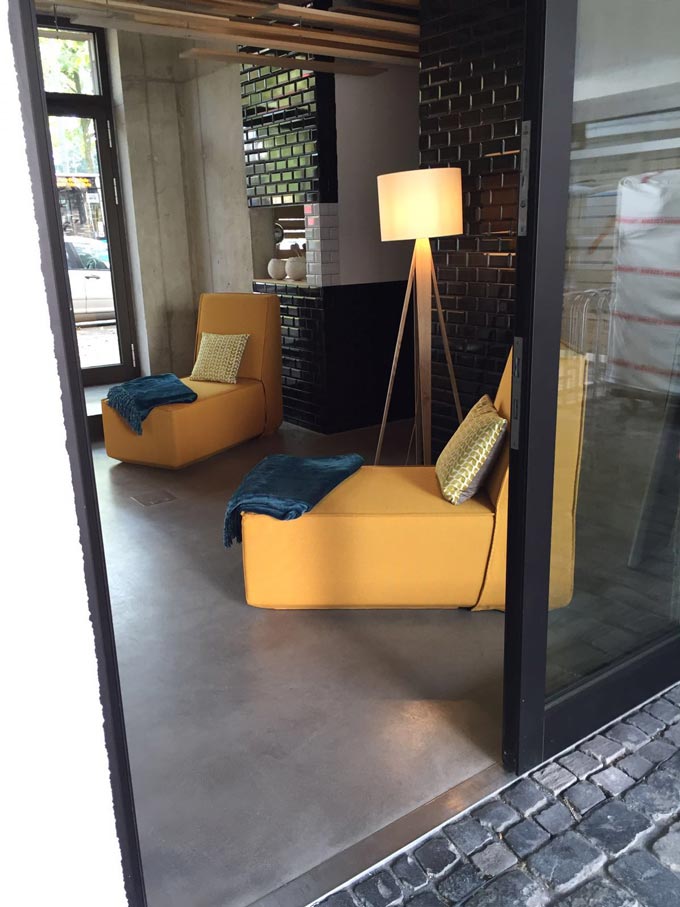 Sneak view of the Concrete Apartments in Koeln. Love the yellow color of the modular Cubit sofas that can be rearranged in any way the residents may wish. Image by Cubit.