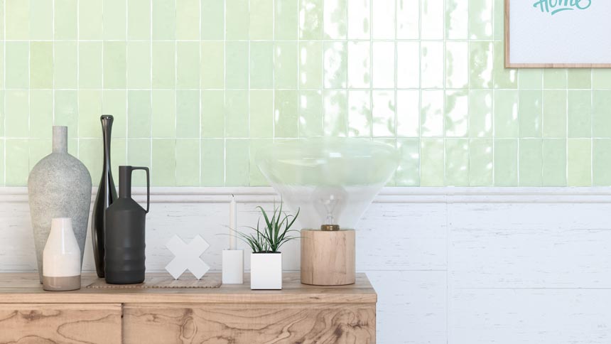 Part of a wall has been tiled with beautiful glossy soft mint green tiles. The sideboard in front of it gives it a bit of an organic and rustic vibe. Image by WOW Design.