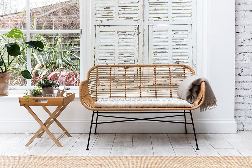 This looks so French or not? A rattan bench with a seat pad and thin, steel legs looking so elegant in front of a vintage looking white window shutter. Image by Garden Trading.