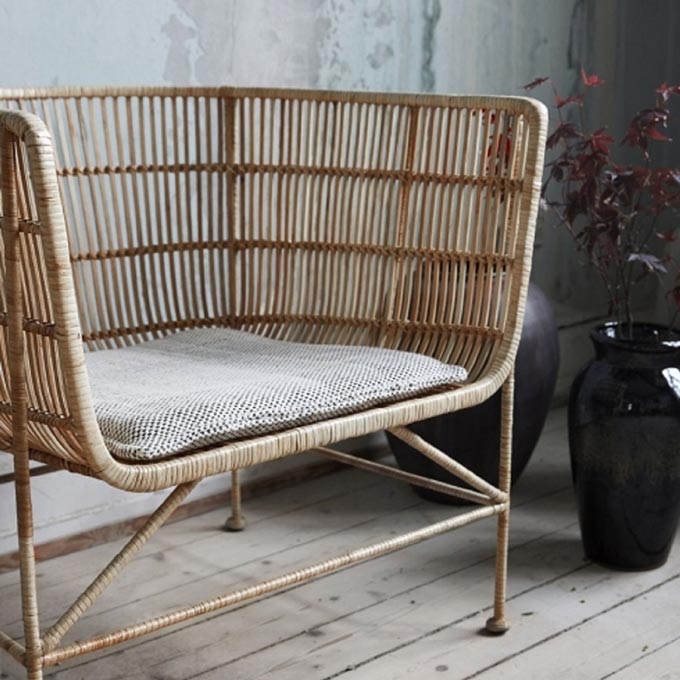 A cozy rattan curved back armchair, Coon by House Doctor. Image by Lagoon. 