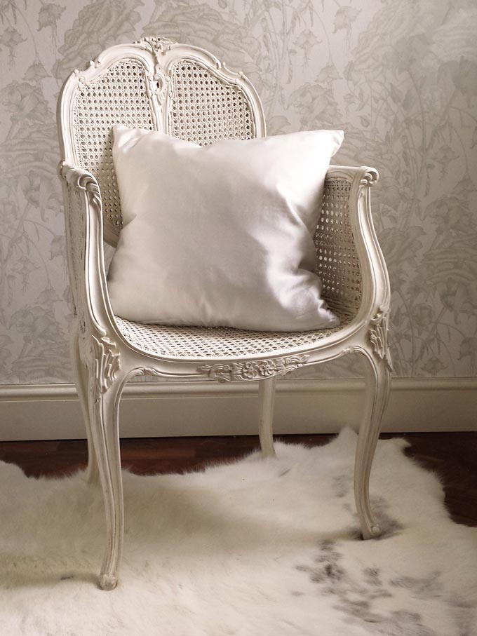 How beautiful is this rattan bedroom chair with an off-white mahogany frame and a flair of a colonial style. Image by The French Bedroom Co.