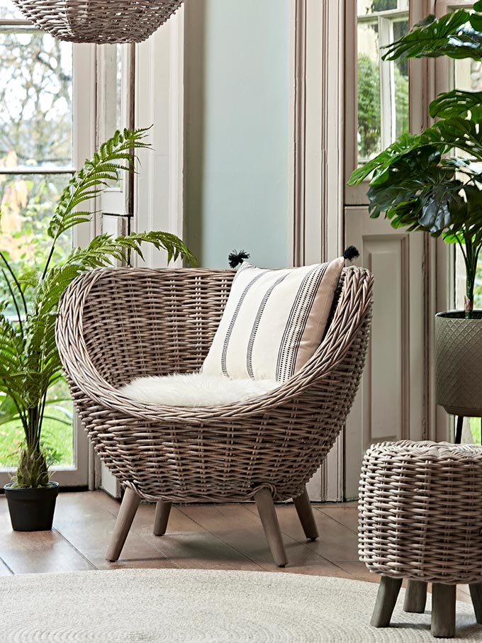 A vignette with a rattan tub chair and simple seating looking elegant. Image by Cox & Cox.