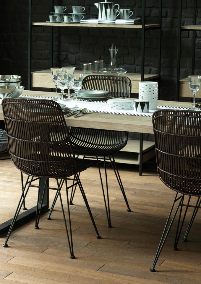 A dining space with a light oak dining table juxtaposing against the retro looking rattan dining chairs in a striking espresso tone. Image by Sweetpea & Willow.