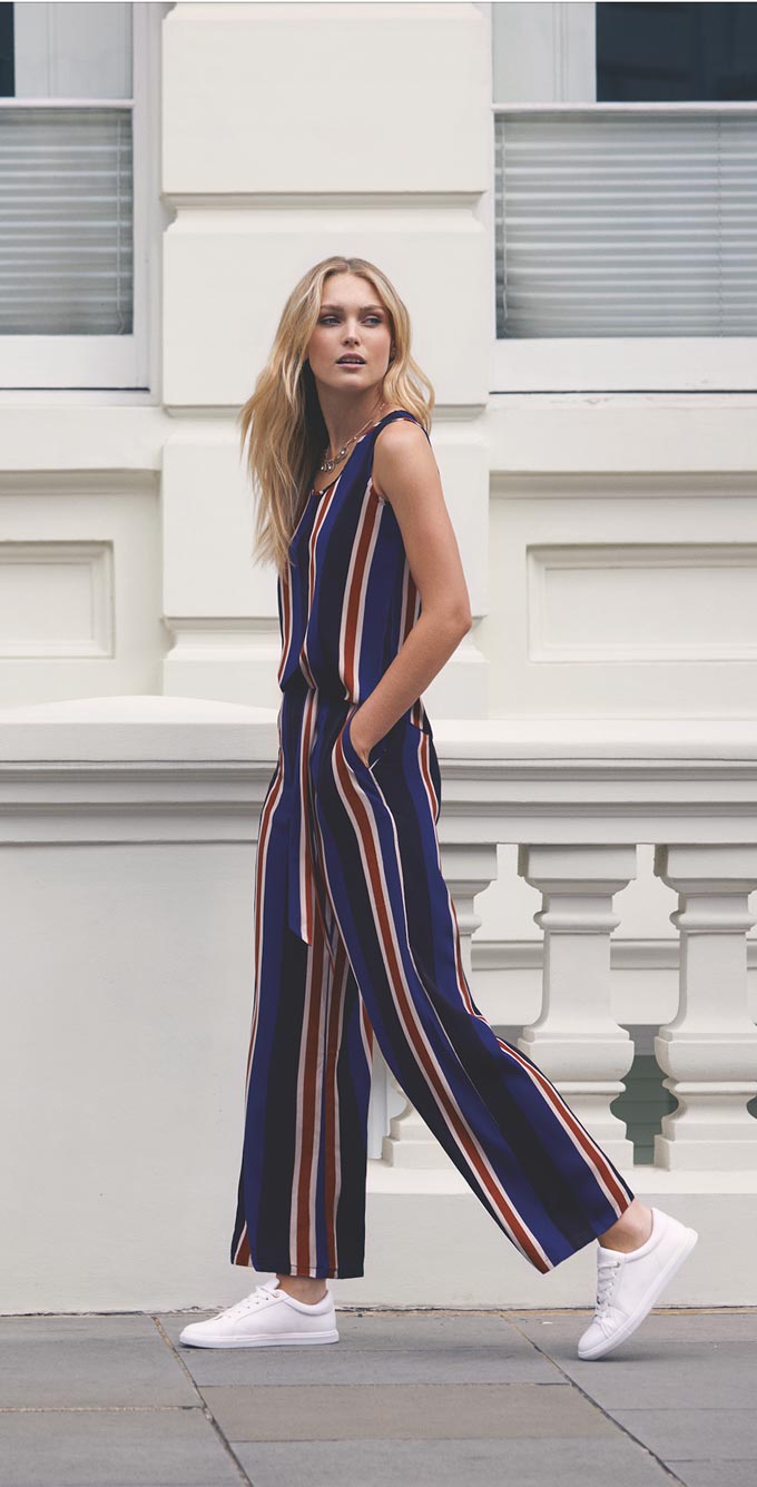 A striped sleeveless jumpsuit paired with some white trainers is a really elegant casual outfit. Image by Apricot.