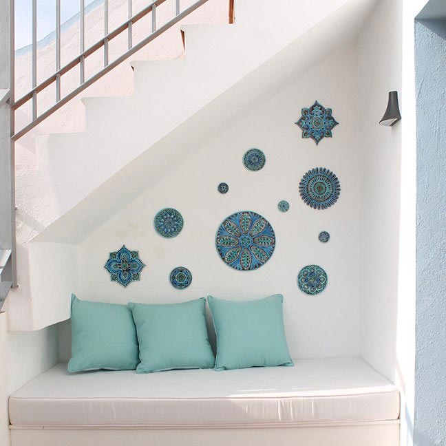 A cozy outdoor alcove under a stairway with a build-in sofa and turquoise decorative tiles that add a summer vibe to it. Image by G. Vega.