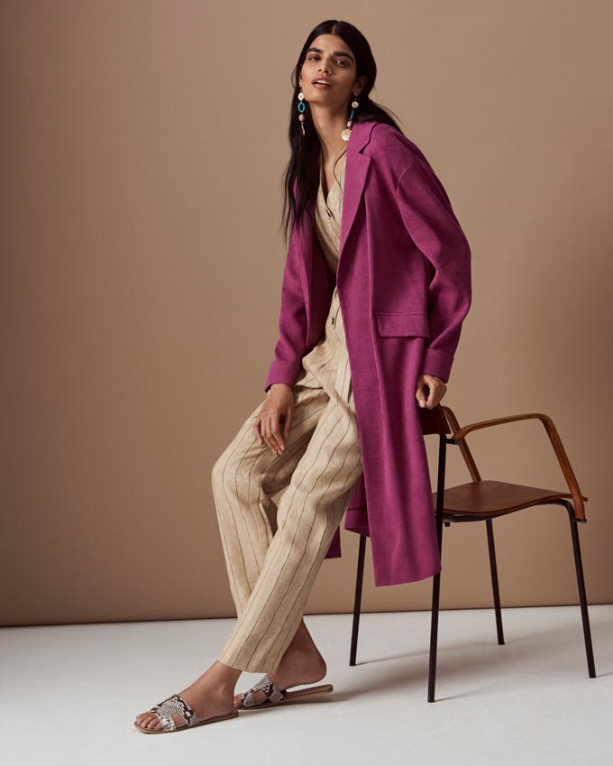 A beige jumpsuit with a mauve coat over it looking stunning. Image by Marks & Spencer.
