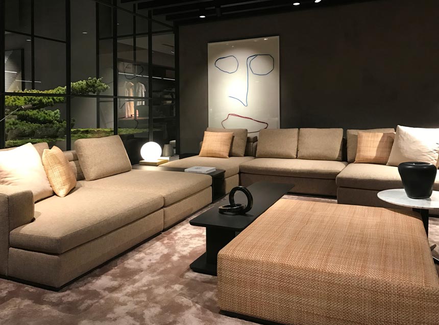 View of a contemporary living space with large comfy beige sofas from the Molteni stand at the imm Cologne 2019 fair.