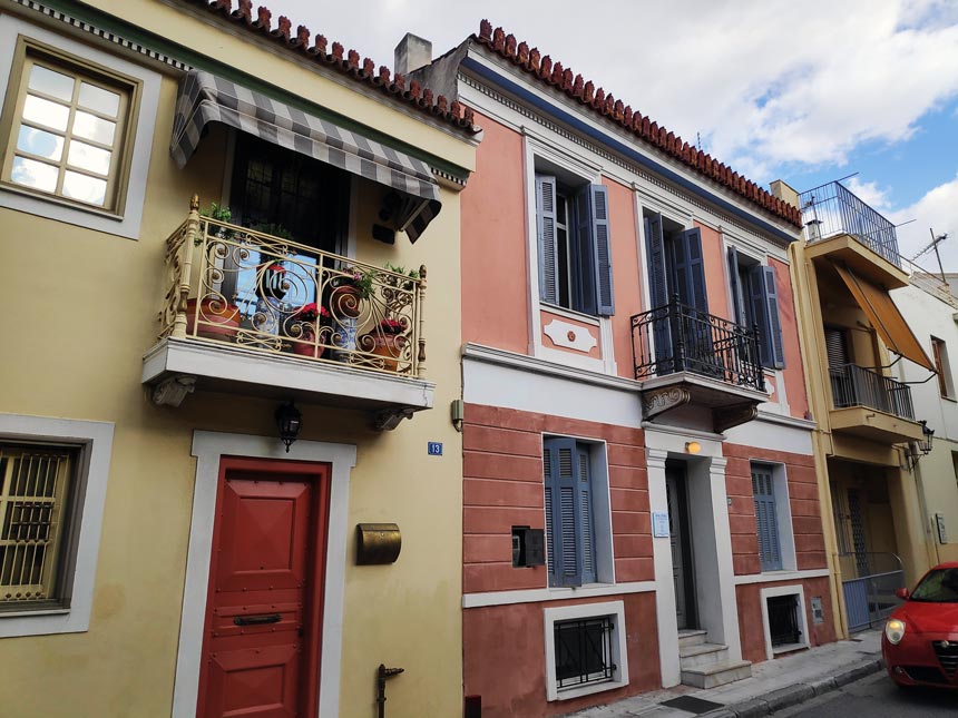 View of the external facades of homes in vibrant colors in Plaka Athens Greece. Image copyright Velvet.