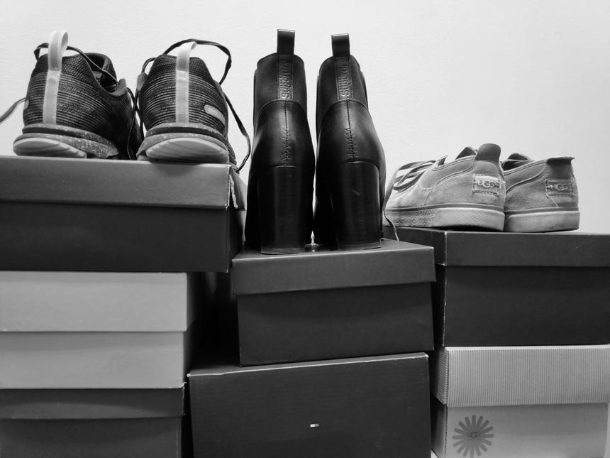 Piles of stacked shoe boxes and three pairs of shoes on top. Image by Velvet.