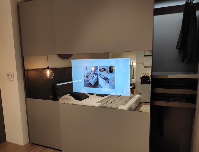 View of a closet's sliding door with a TV monitor embedded within the mirror glass paneling of the door as seen from Maronese ACF at iSaloni 2019 in Milan.