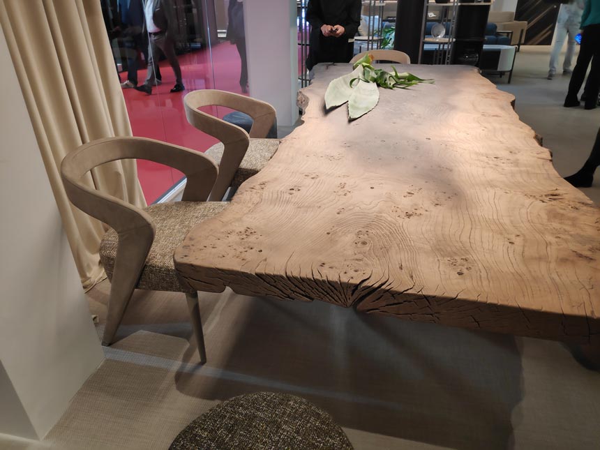 A dining table and curvy dining armchairs with a solid wood frame looking very textured and organic.