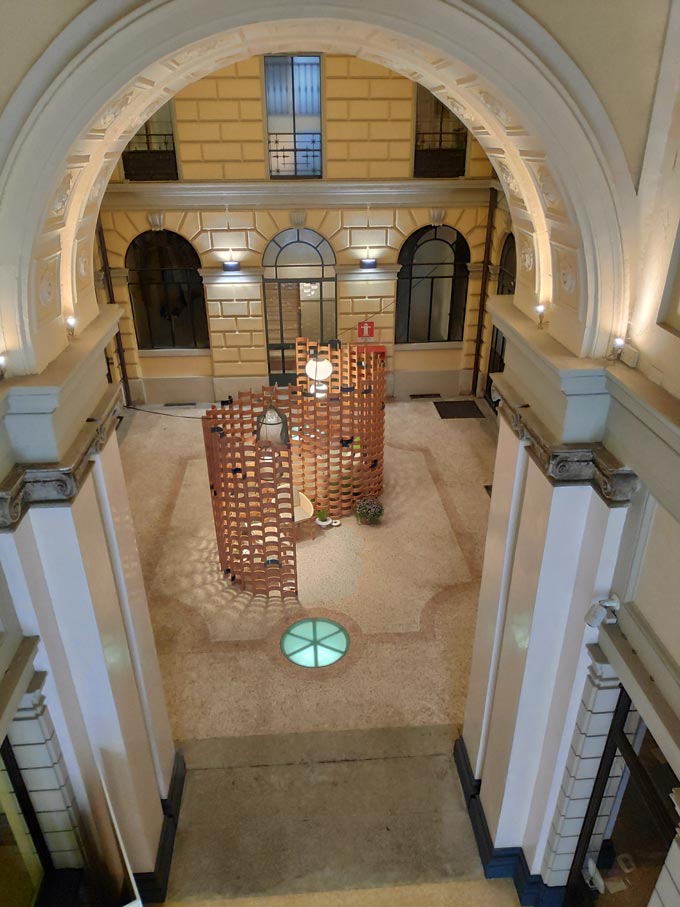 View from above of part of an installation with Spanish design products that include armchairs, space divider with clay bricks, sofa and pots.