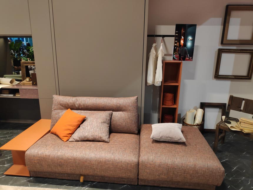 A modular sofa that turns into a bed in front of a closet by Tumidei at iSaloni 2019 in Milan.