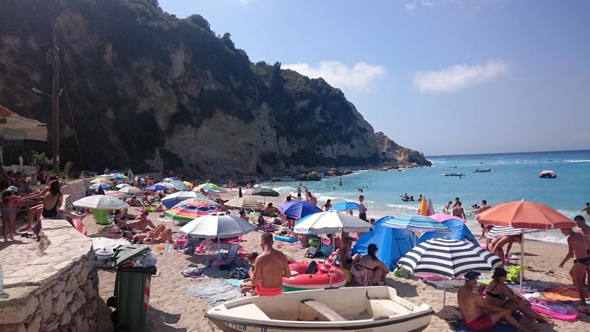 View of the the packed by people Agios Nikitas beach in Lefkada.