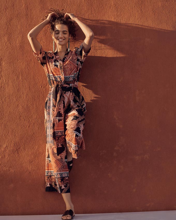 A geometric print jumpsuit in rusty hues and inky stains looks so edgy and refined. Image by Next.