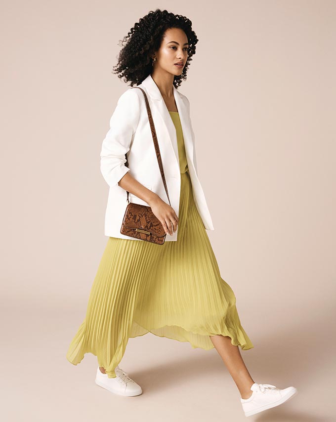 I would love to wear an outfit like this: a white blazer over a pale yellow pleated maxi dress and white sneakers. Image by Oasis.