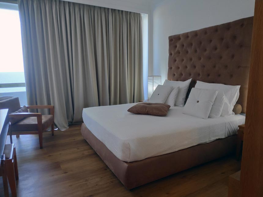 Partial view of a master bedroom with its stunning headboard of a Grecotel Lux Me Rhodos apartment.