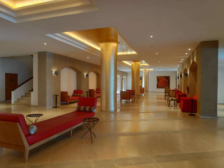 Partial view of the greater lobby area near the reception at the Grecotel Lux Me Rhodos with lots of red sofas everywhere.