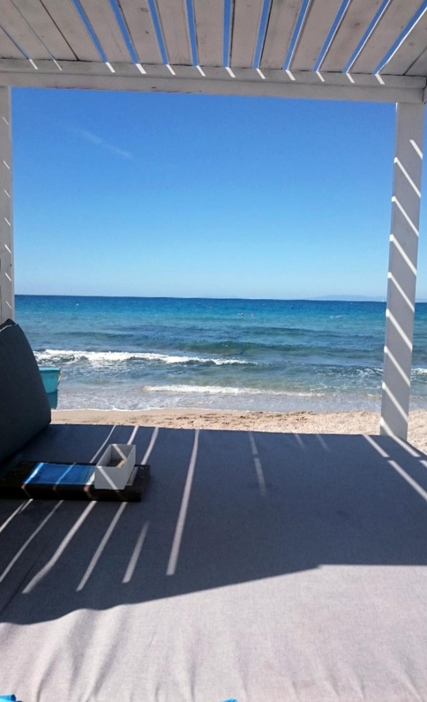 Looking at the sea from a gazebo on a sandy beach in Lagonissi.