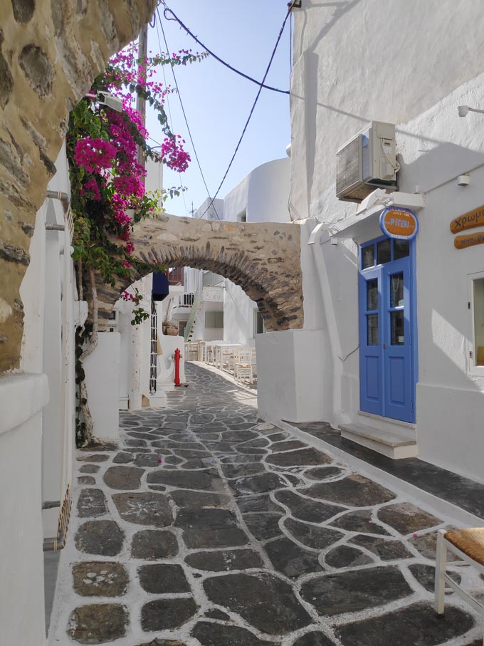 A stone cobbled alley with white washed houses at Naoussa, Paros.