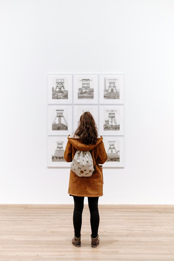 A woman at a gallery looking at an art work.