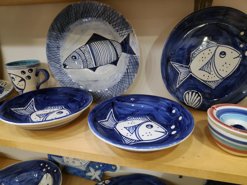 Ceramic platters by Maria Banou with fish painted on them.