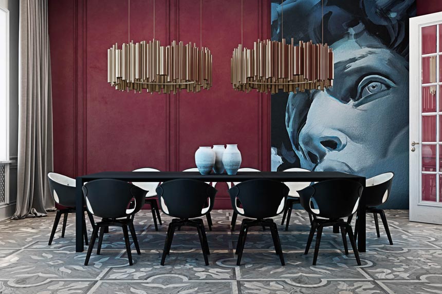 View of a gorgeous dining room featuring a burgundy accent wall with an oversized artwork, gold metallic pendant lights and a black and white dining set. 