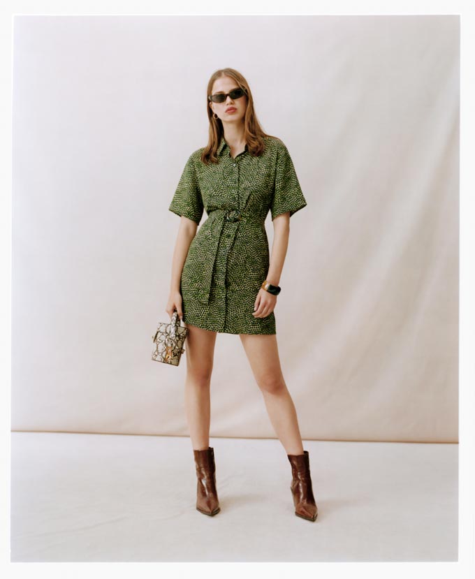 A mini green print dress paired with a small handbag and ankle boots. Image by Topshop.