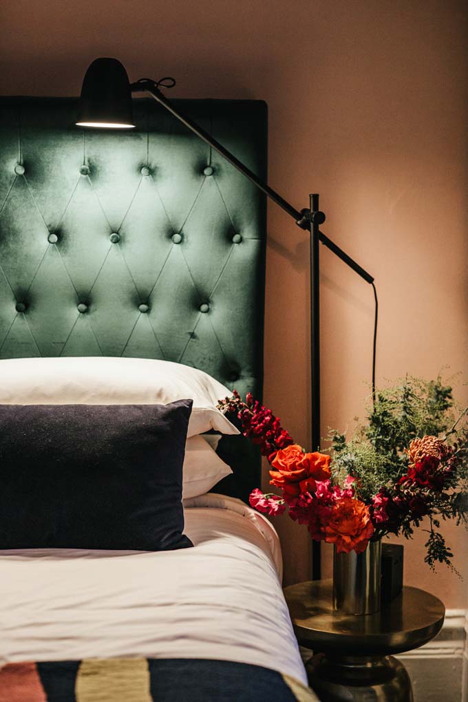 Detail view of a green headboard and bed from one of the rooms of Hotel Harry at Surry Hills, Sydney.