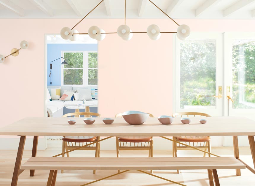 A bright contemporary dining space with BM's First Light pink hue walls. Image via Benjamin Moore.