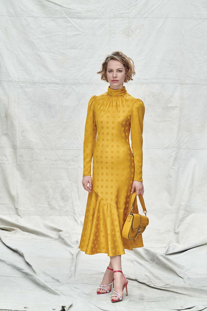 A yellow dress with a yellow saddle bag and high heel sandals. Image via Dorothy Perkins.