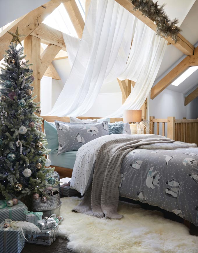 Another green Christmas tree with silver decorations and a very soft vibe to it. It looks perfect in this attic bedroom. Image via Dunelm.