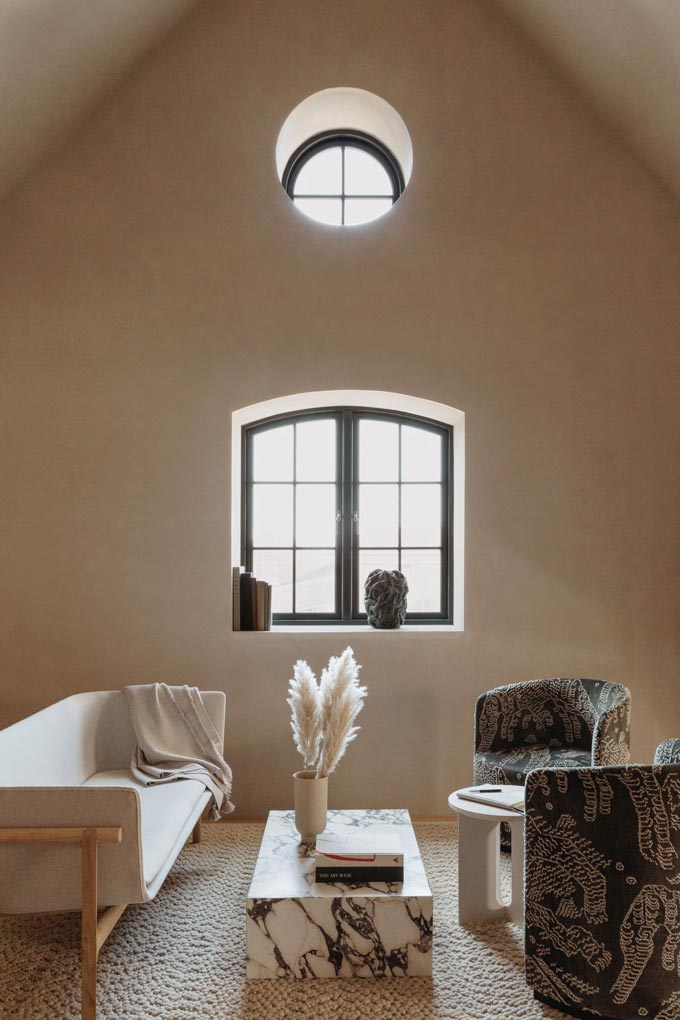 A cozy living room under a sloped roof featuring Menu low plinth marble coffee table. Image via Nest.co.uk. Marble decor ideas.